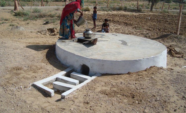 Rainwater harvesting: Real image of a woman drawing water from a 'Taanka' in Rajasthan